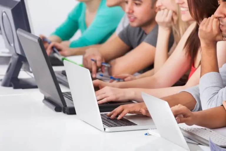 Group of people working on laptops in a collaborative environment.